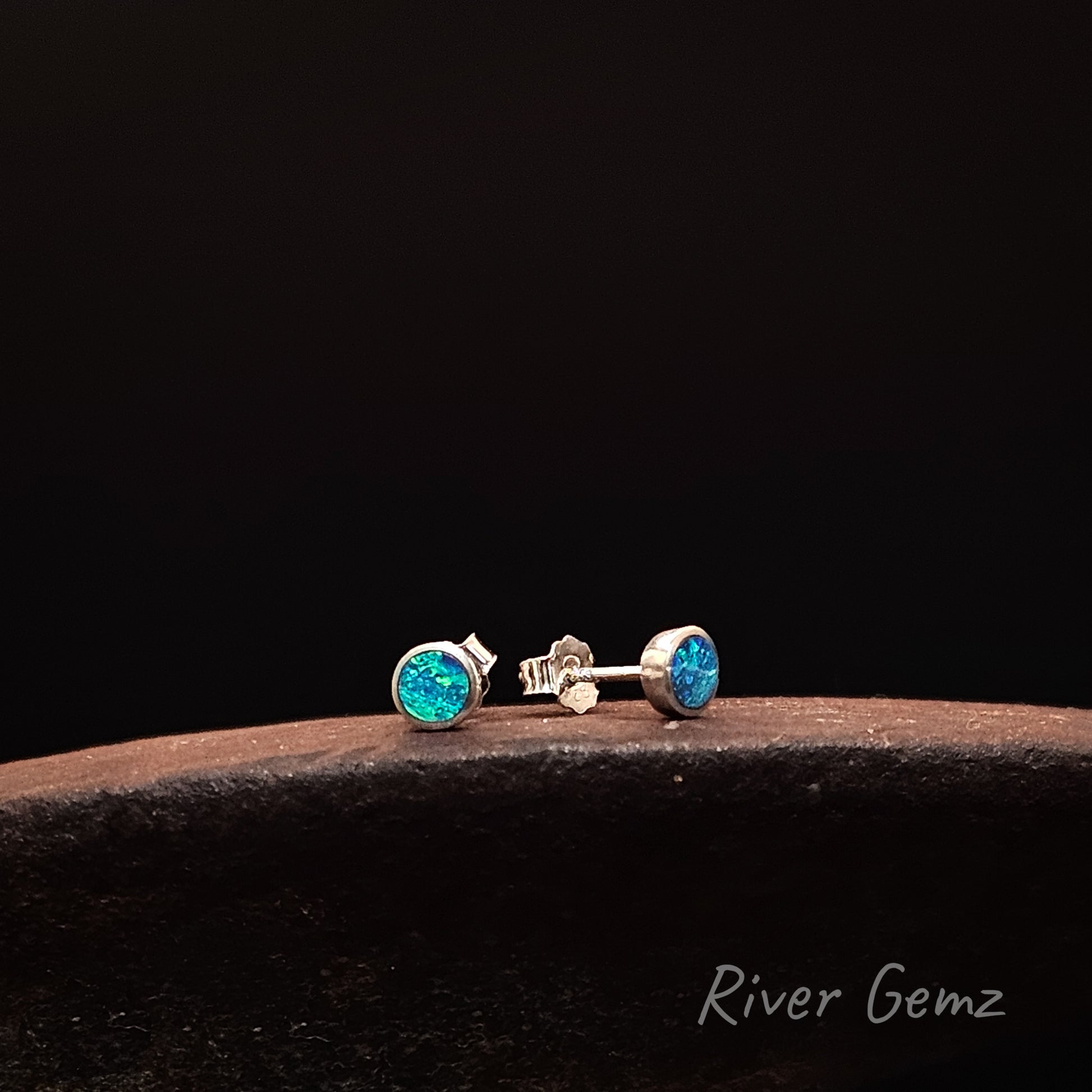 Silver earrings with turquoise gemstones on a dark background, branded 'River Gemz'.