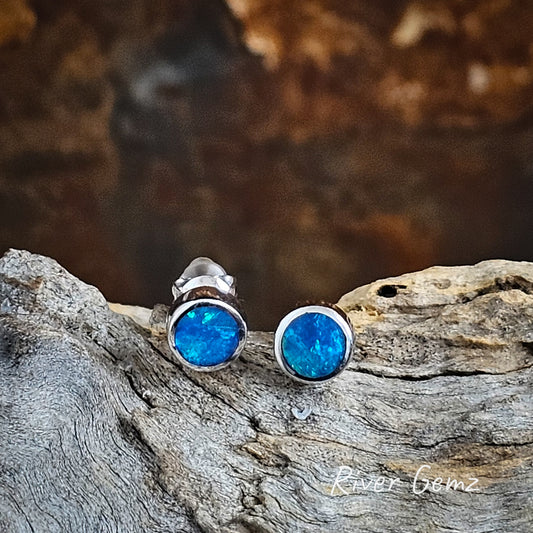 Round blue and green opals set in silver stud earrings.