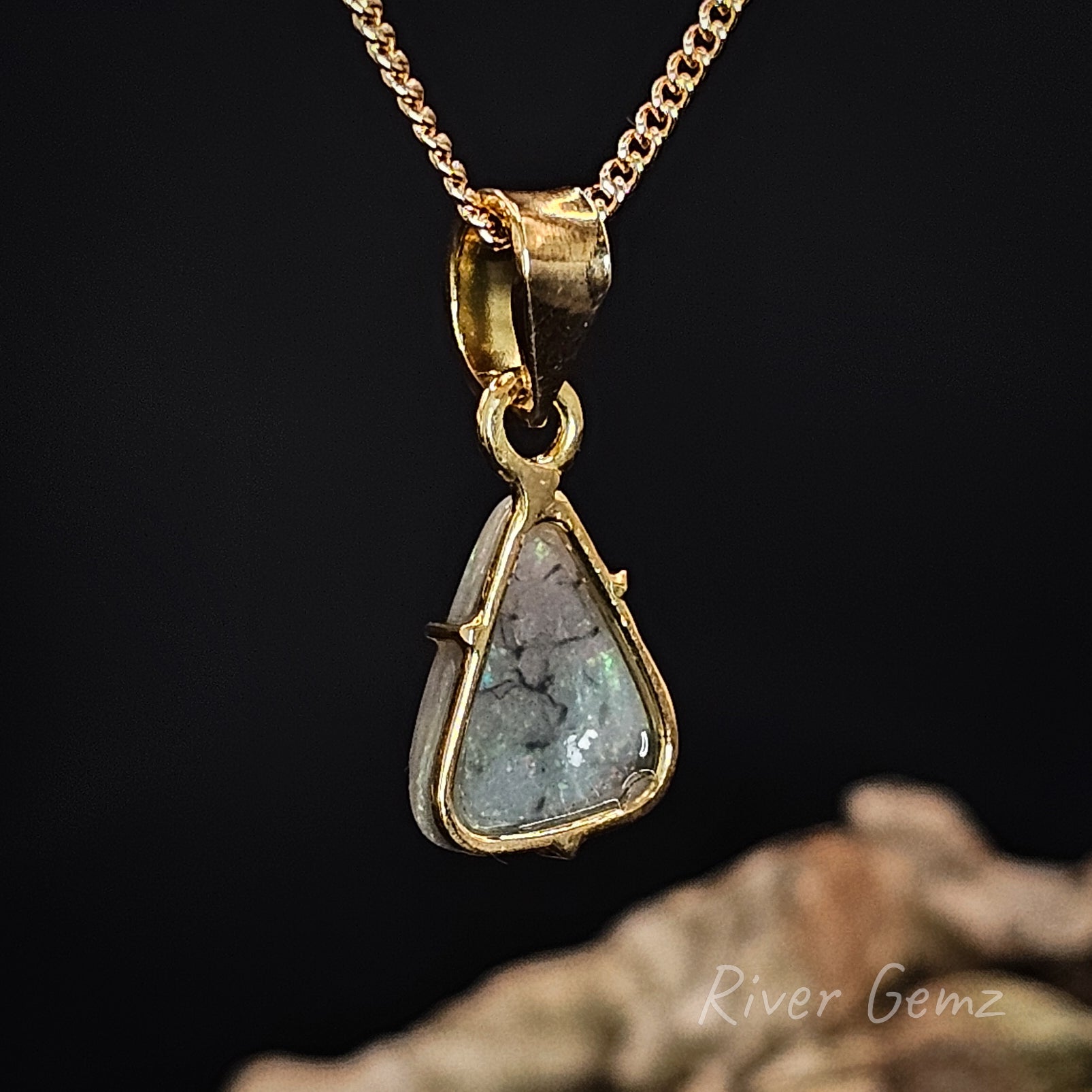 Rear view of the gold pendant shows the grey base tone of the included semi-black opal.