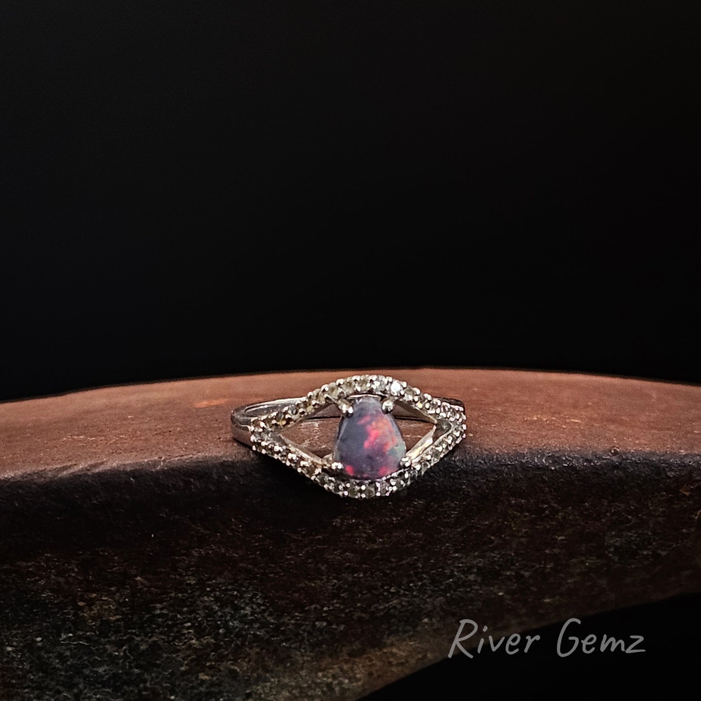 Fire red in dark opal with white topaz stones in sterling silver ring.
