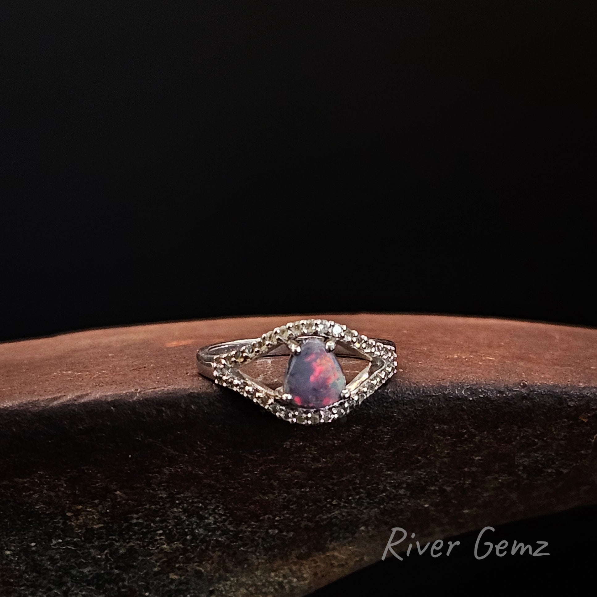 Fire red in dark opal with white topaz stones in sterling silver ring.