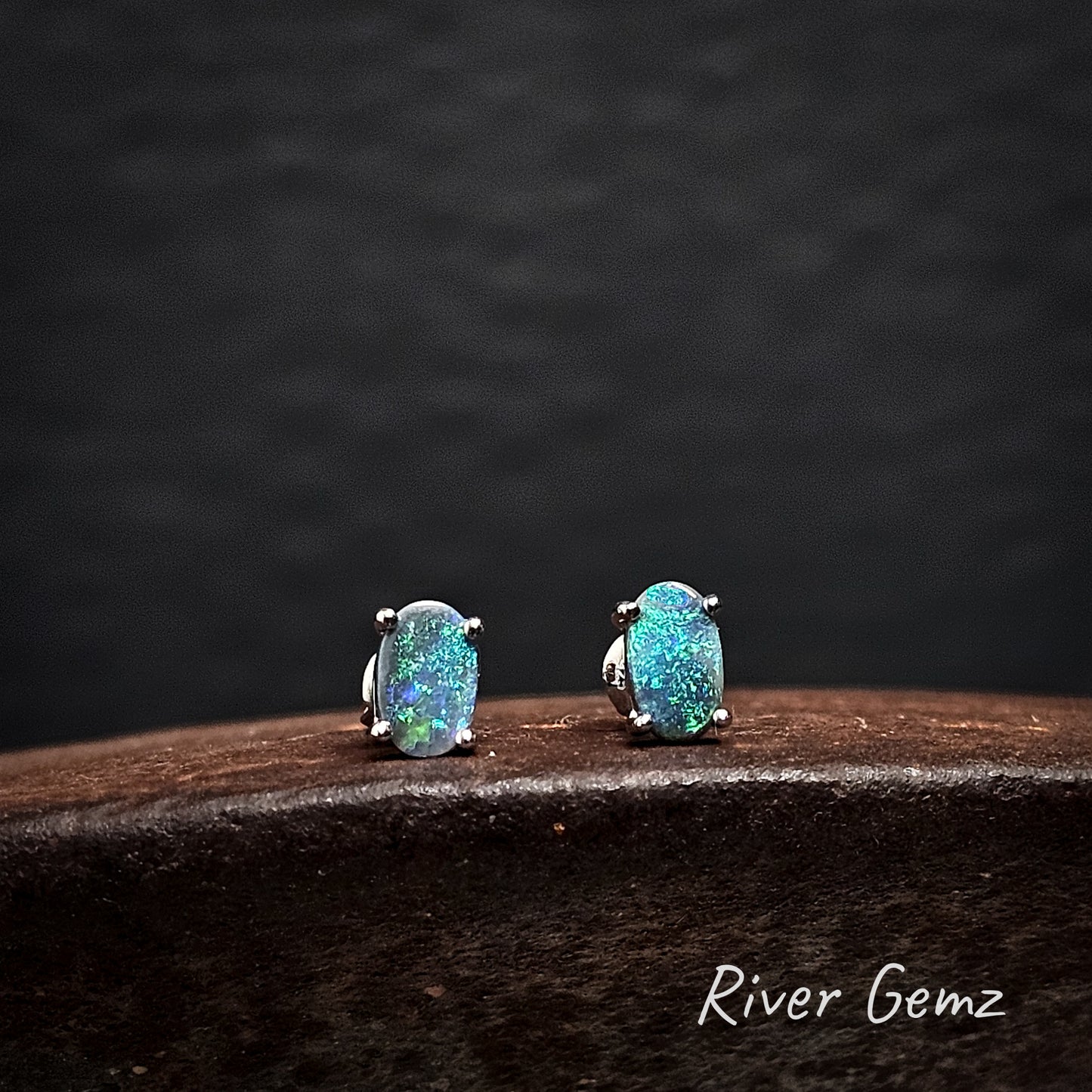 Pair of turquoise opal earrings on a dark background with 'River Gemz' branding.