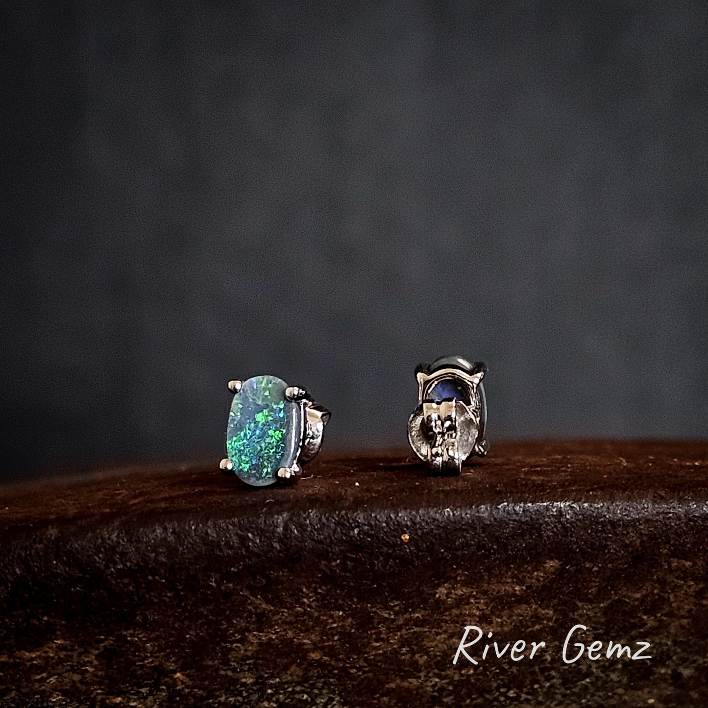 Two sterling silver earrings with green dark opals on a dark background, branded 'River Gemz'.