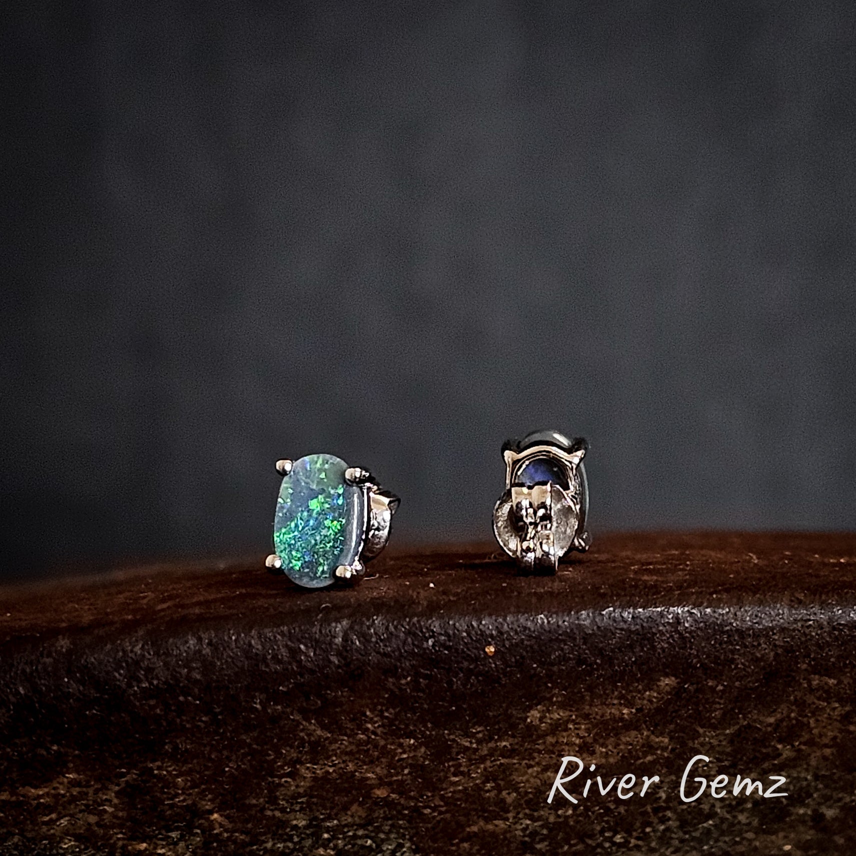 Two sterling silver earrings with green dark opals on a dark background, branded 'River Gemz'.