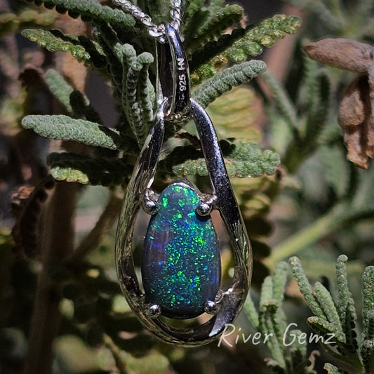 Dark opal with colours like a distant gallexy in a modern silver pendant.