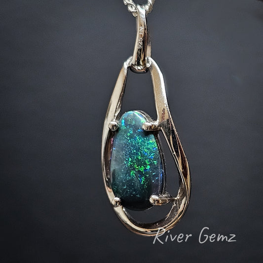 Black opal claw set in pear shaped silver necklace.