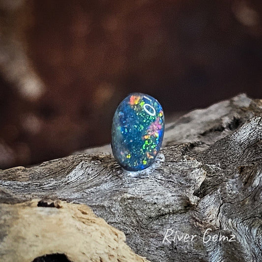 Oval shaped multi-coloured black unset opal.