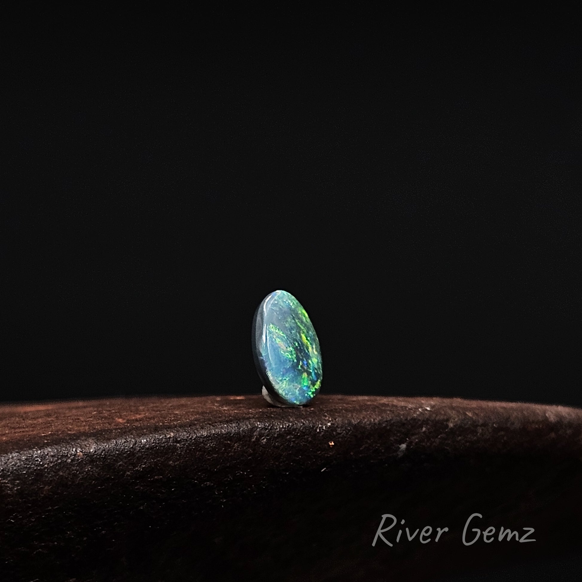 Opal stone on a dark background with 'River Gemz' branding.