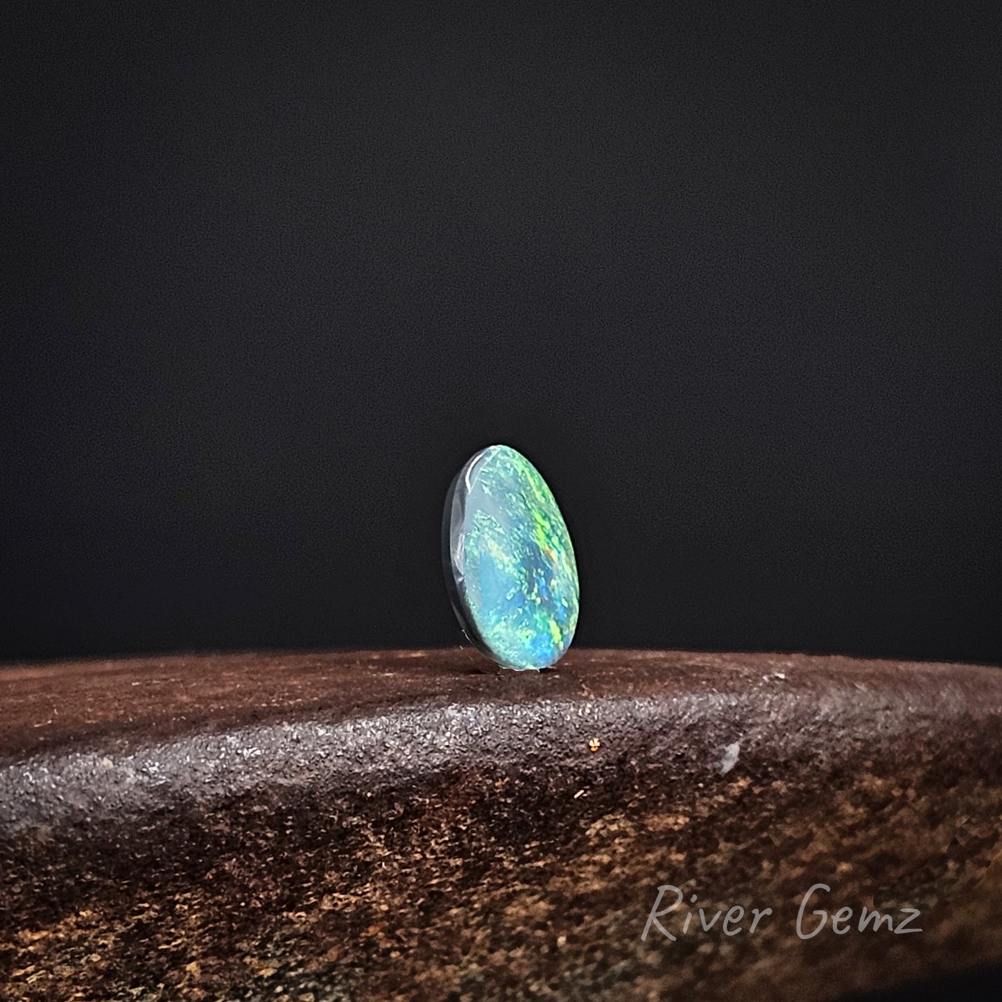 Opal stone on a dark background with 'River Gemz' branding.