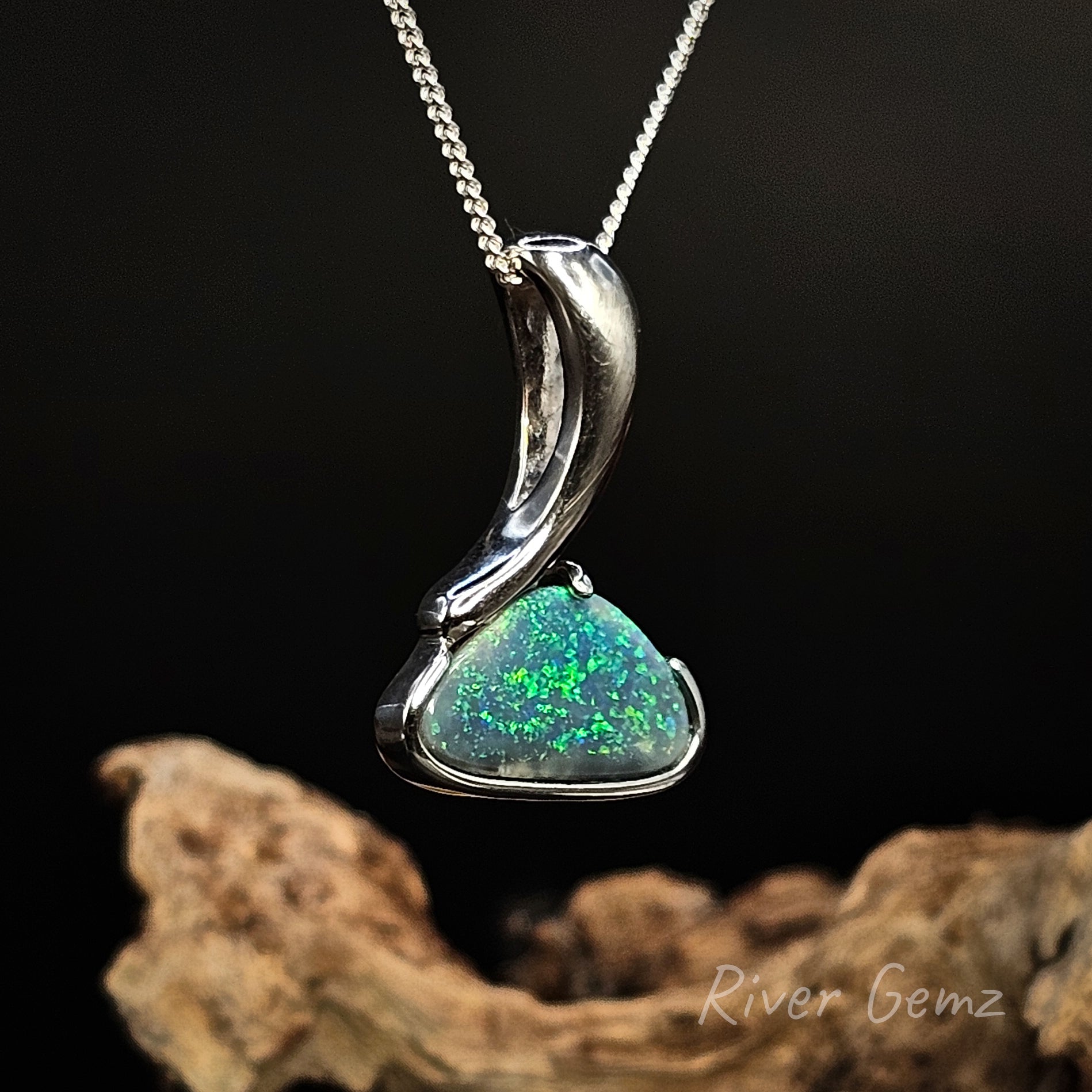 Opal pendant on a chain with a dark background and 'River Gemz' branding.