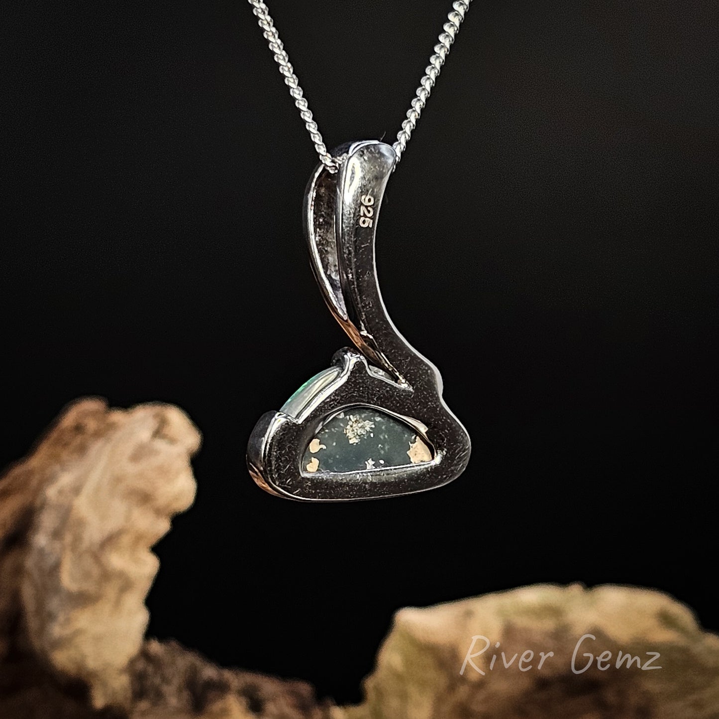 Rear view of necklace shows the dark tone of the black opal on a dark background, featuring 'River Gemz' branding.