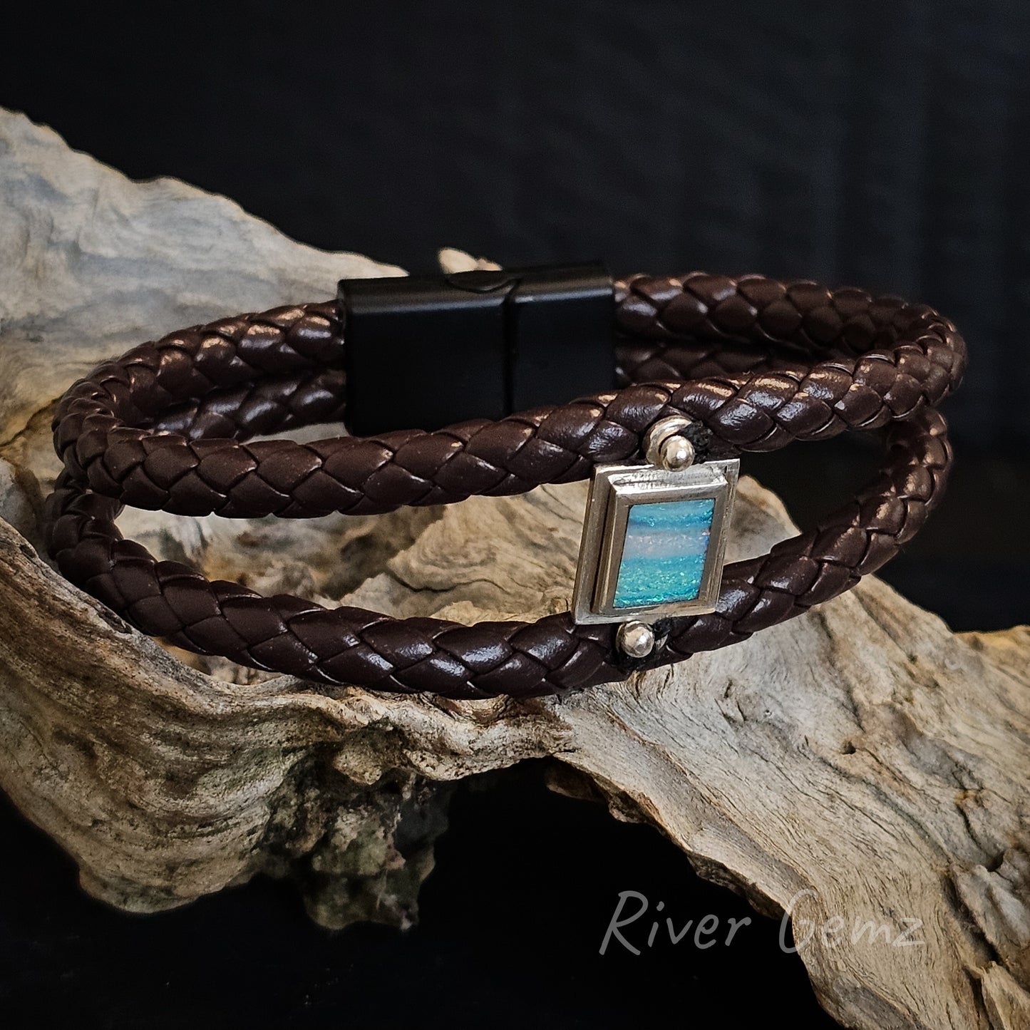 Brown braided leather bracelet with black lock with rectangular shaped multi-coloured opal set in sterling silver.