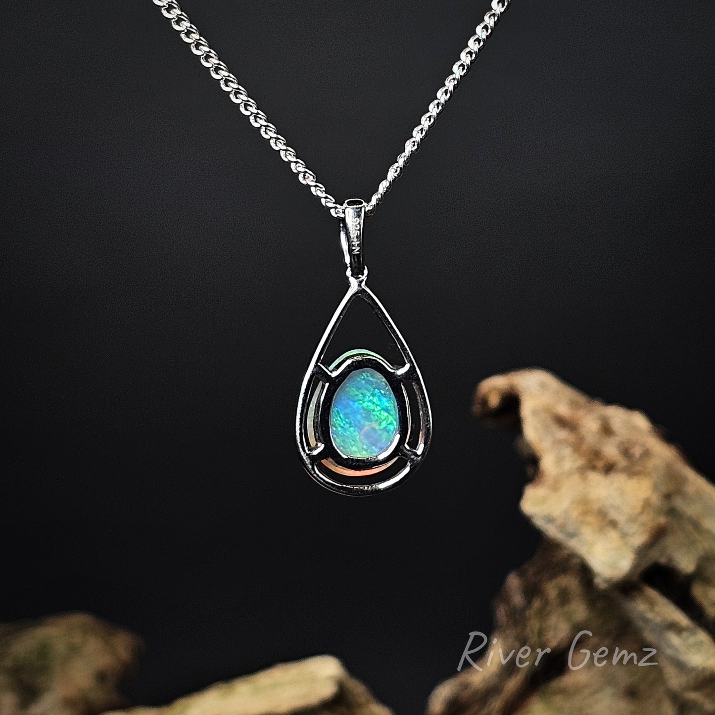 Rear view of the necklace shows the blue and green colour continues throughout the opal. 925 stamp indicates sterling silver.