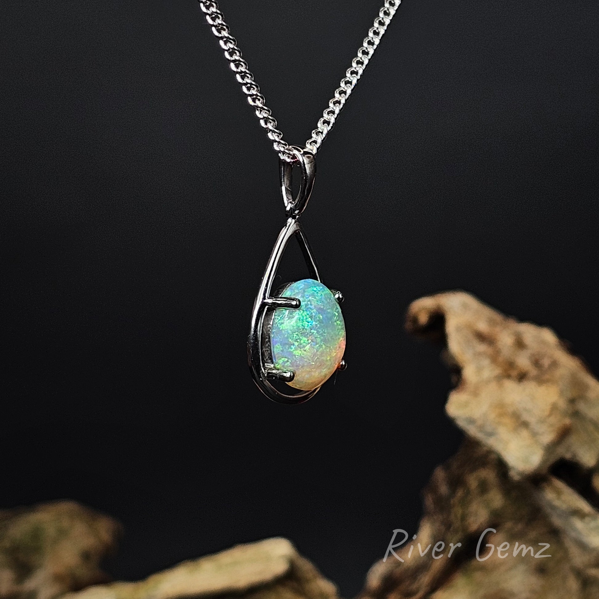 Opal claw set in sterling silver  necklace on a dark background with 'River Gemz' branding.