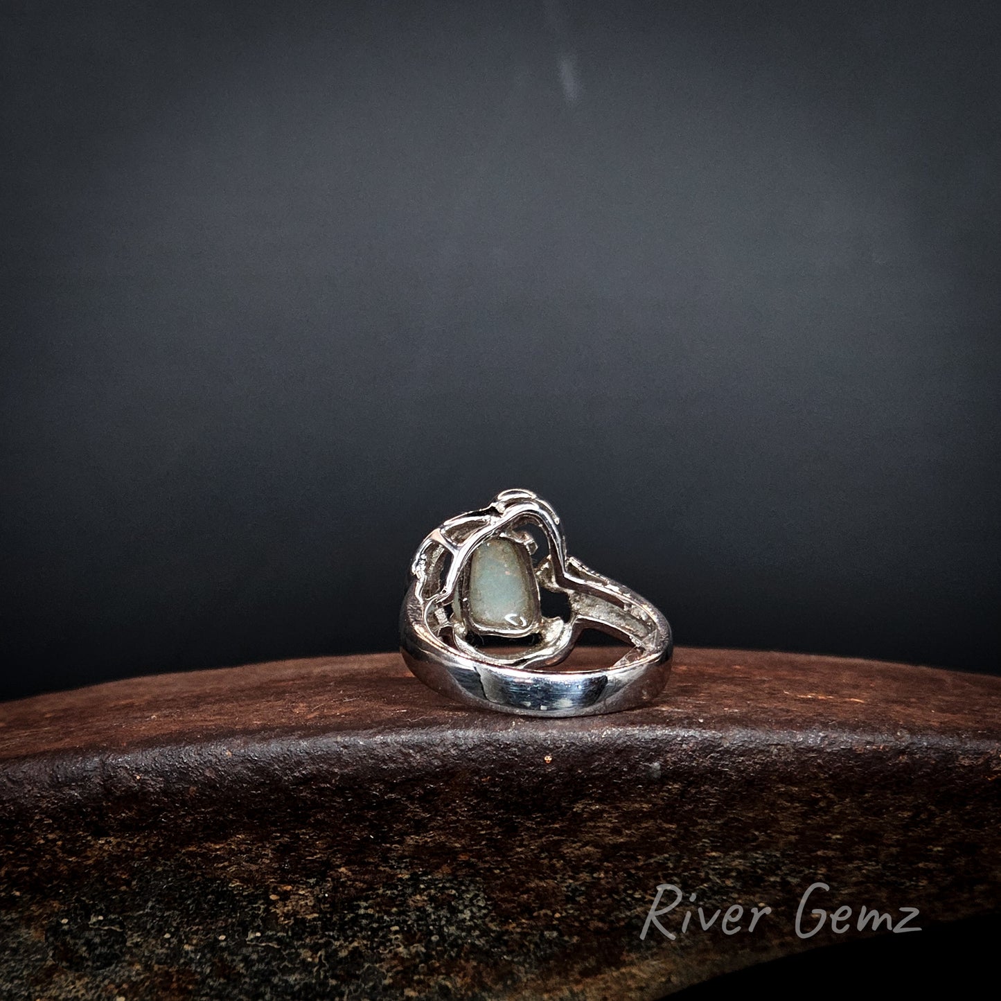 Rear view shows the light base tone of the crystal opal set in the ring.