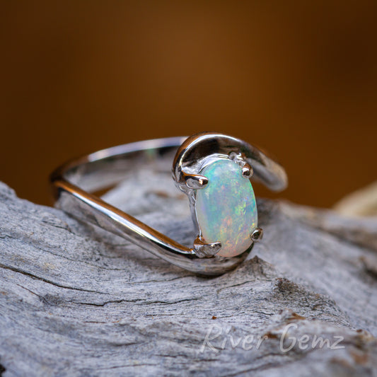 Oval-shaped multicoloured light opal held with 4 claws in a silver ring.