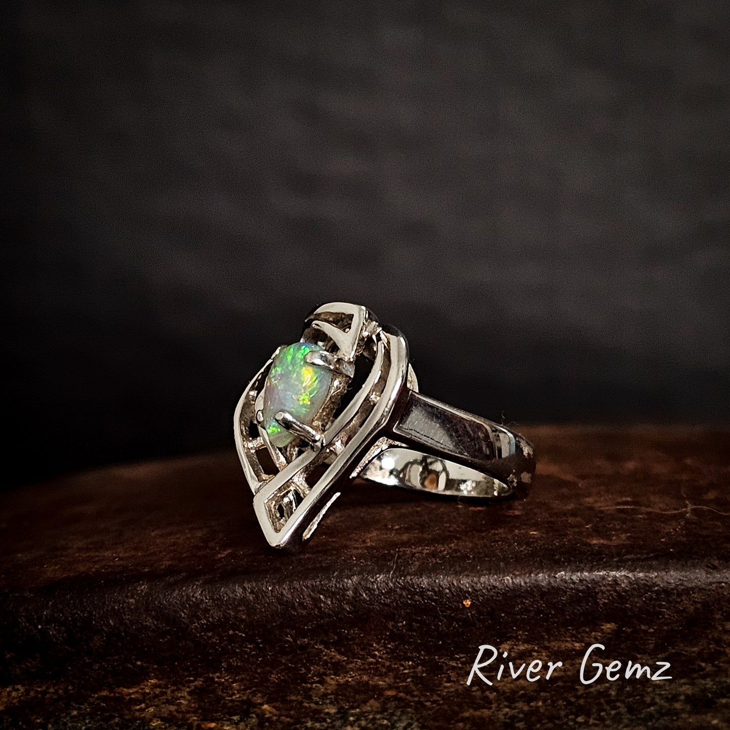 Silver ring with a green crystal opal on a dark background, featuring the brand 'River Gemz'.