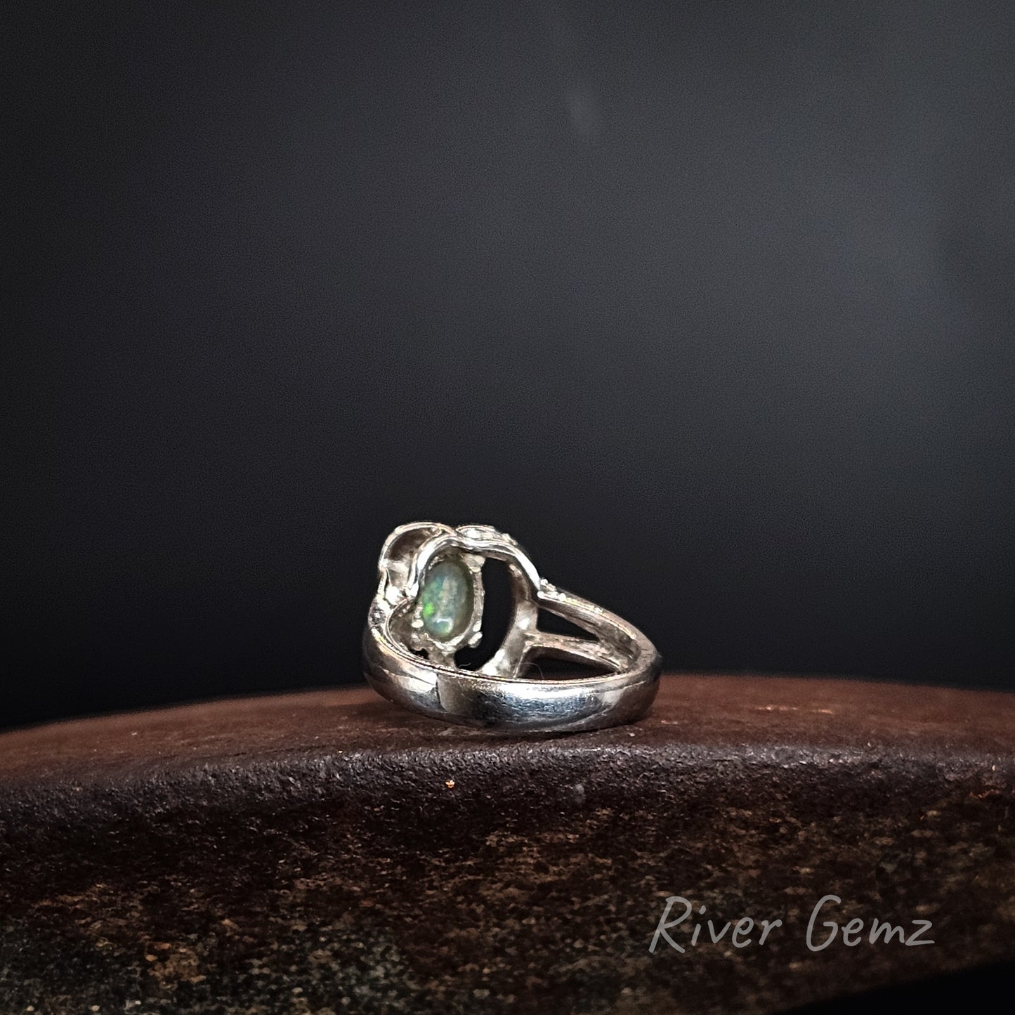 Rear view of silver ring showing the light base tone of the crystal opal in the ring. The brand name 'River Gemz' is visible as a watermark in the bottom right corner.