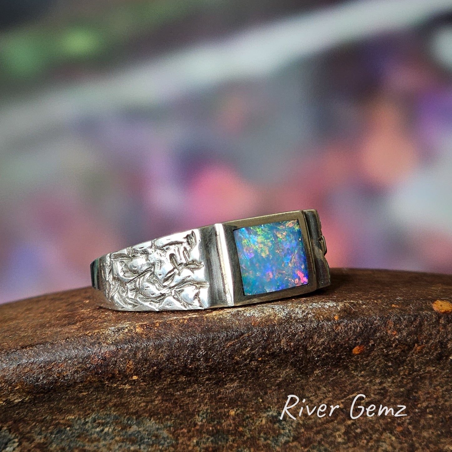 Leaf-type shapes etched into shoulders of the opal and silver men's ring.