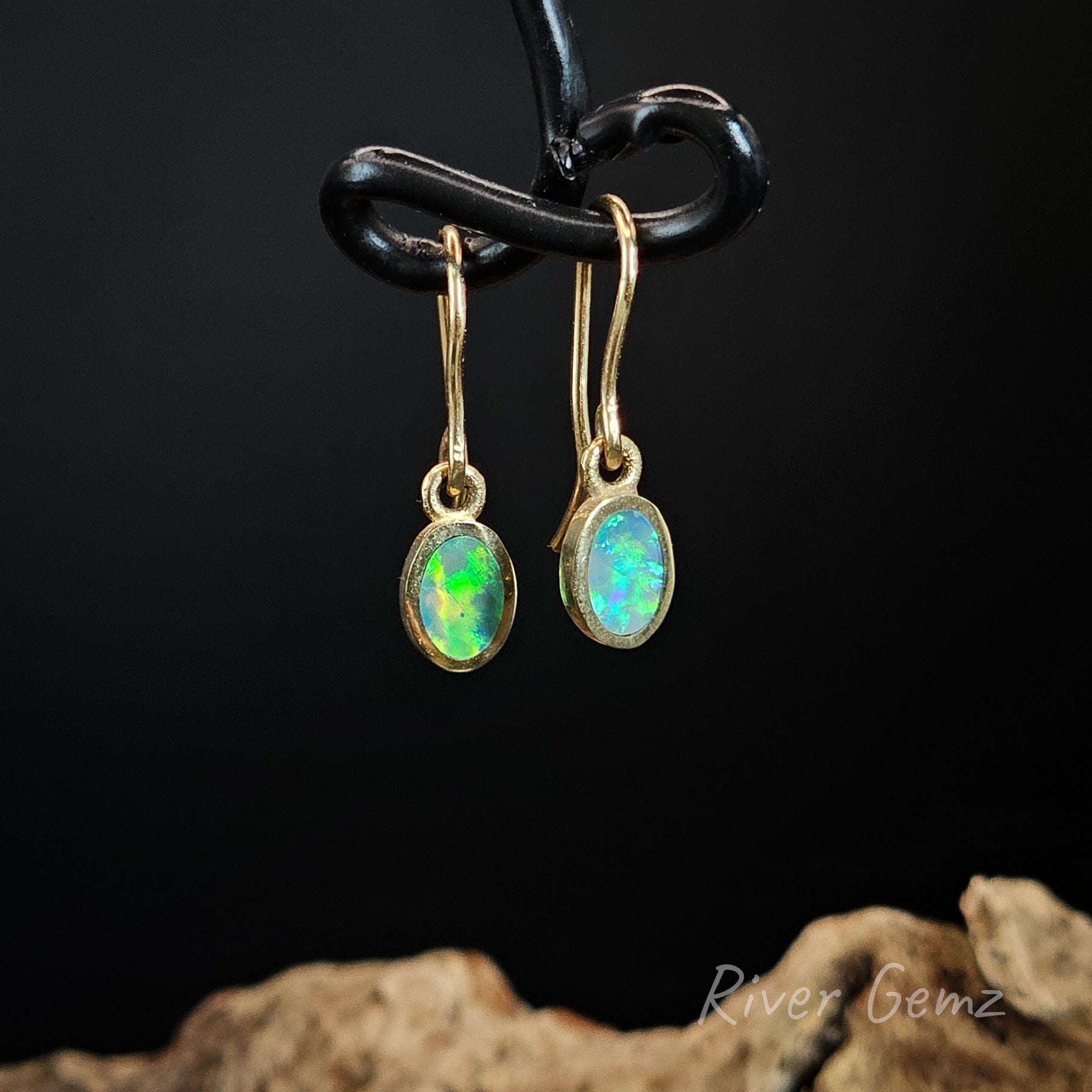 Blue and green light opals set in yellow gold hooks.