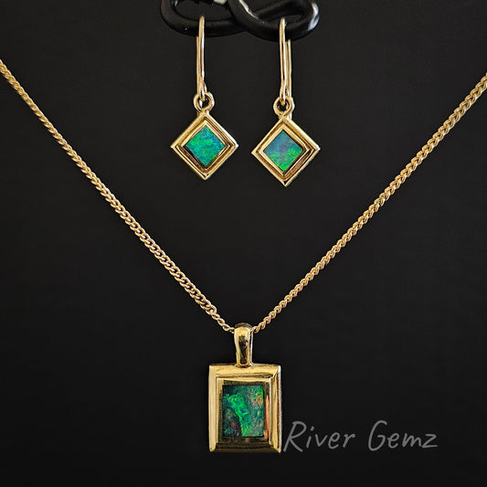 Hook earrings with matching pendant besel set in yellow gold against a black background.