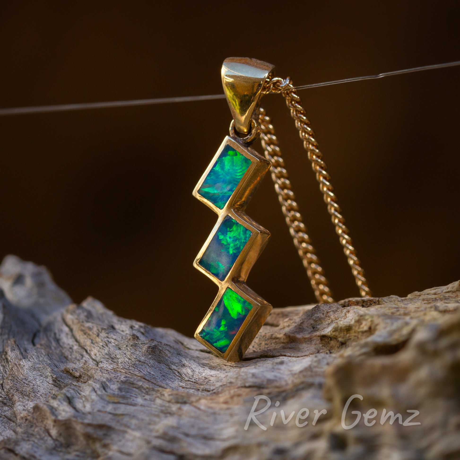 Three rectangular opals individually besel set and connected at a corner of the rectangle. Large bail connected to the eyelet at the top of the stair-case like pendant.