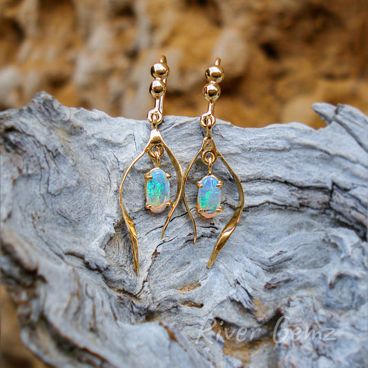 Oval shaped opals with thin golden-arms embracing each.