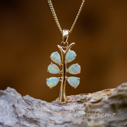 Six opals claw set around the trunk of the tree forming its branches. Chain passes through the typically tapered bail to complete the pendant.