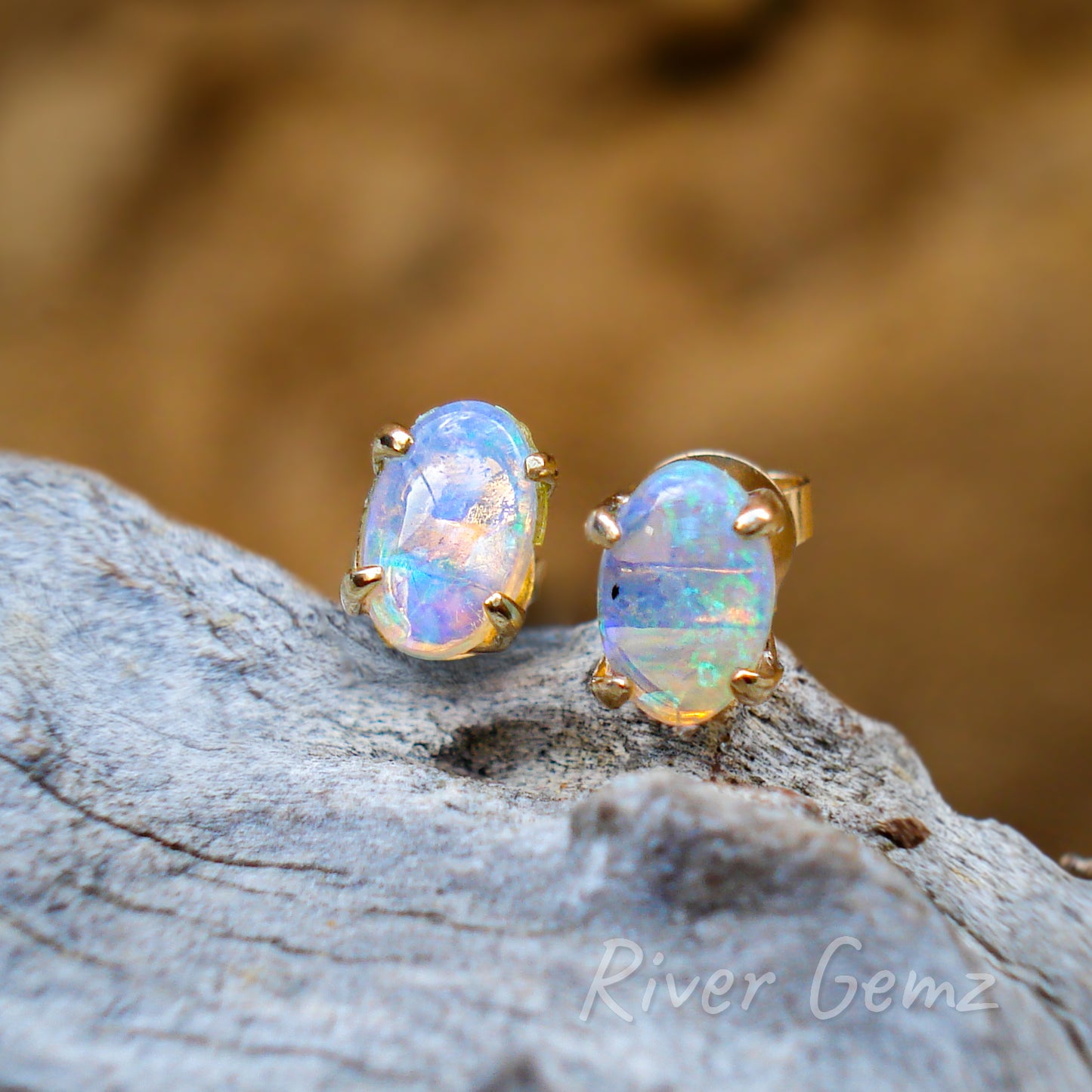 Oval shaped transparent opals held with 4 claws in each gold stud.