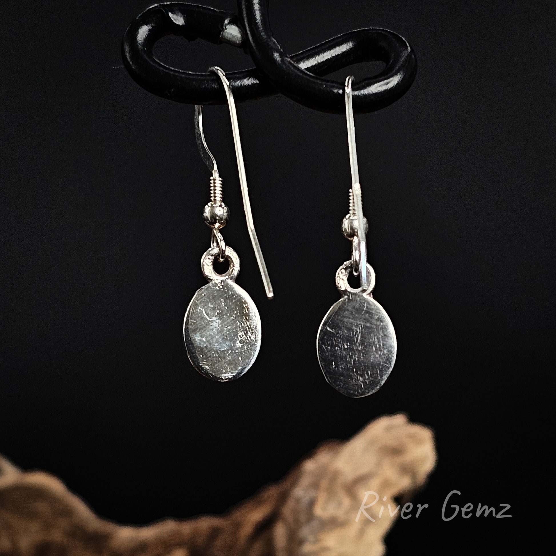 Rear view of the shepherd hook earrings show the silver backing behind the crystal opals.