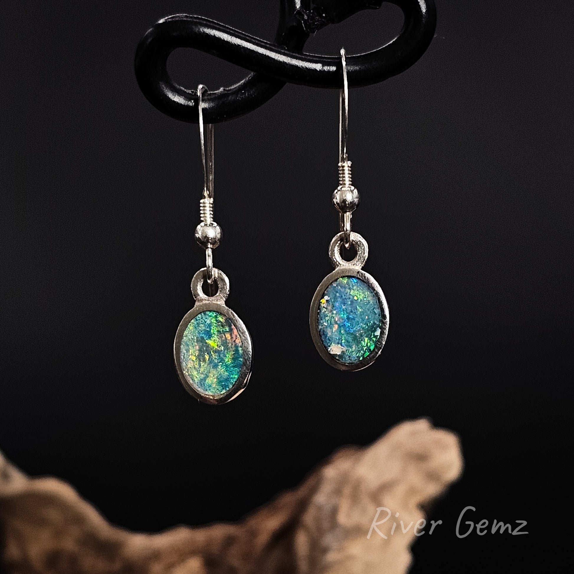 Oval shaped multi-coloured opals set in sterling silver hook earrings.