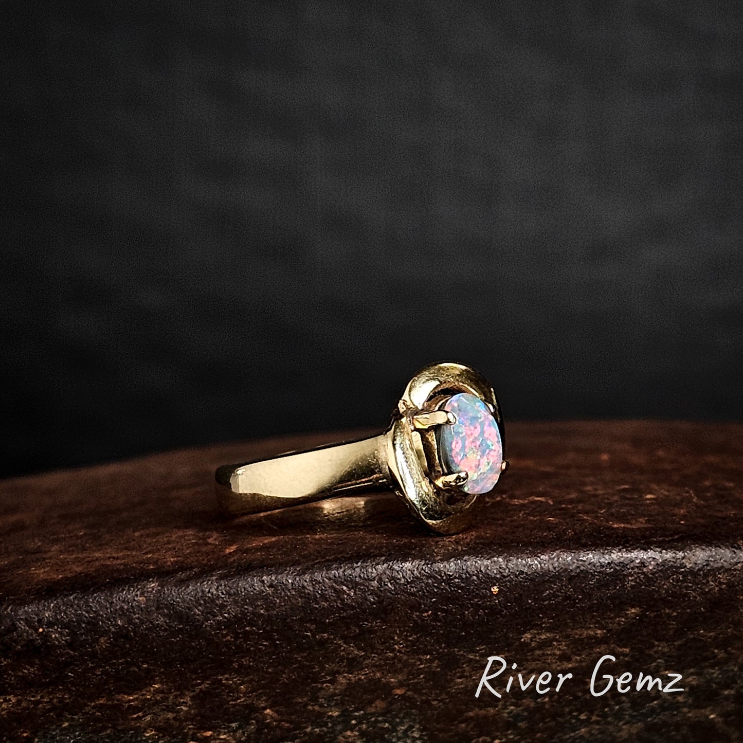 Colourful semi-black opal set in yellow gold ring.