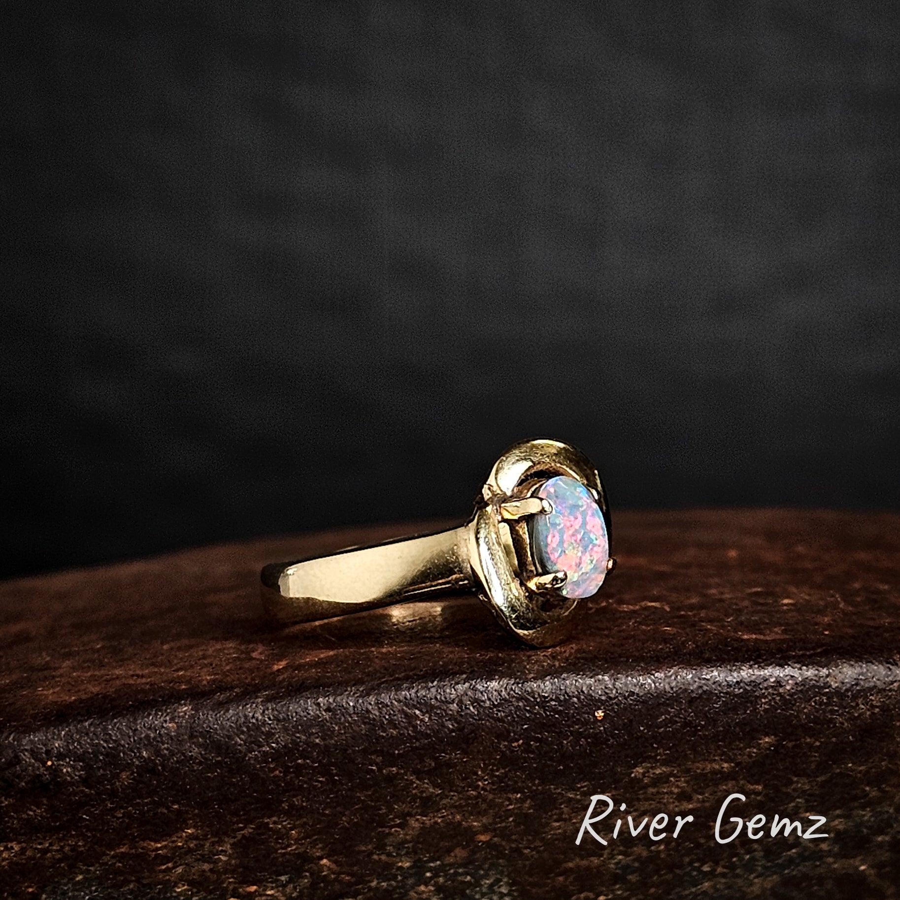 Colourful semi-black opal set in yellow gold ring.