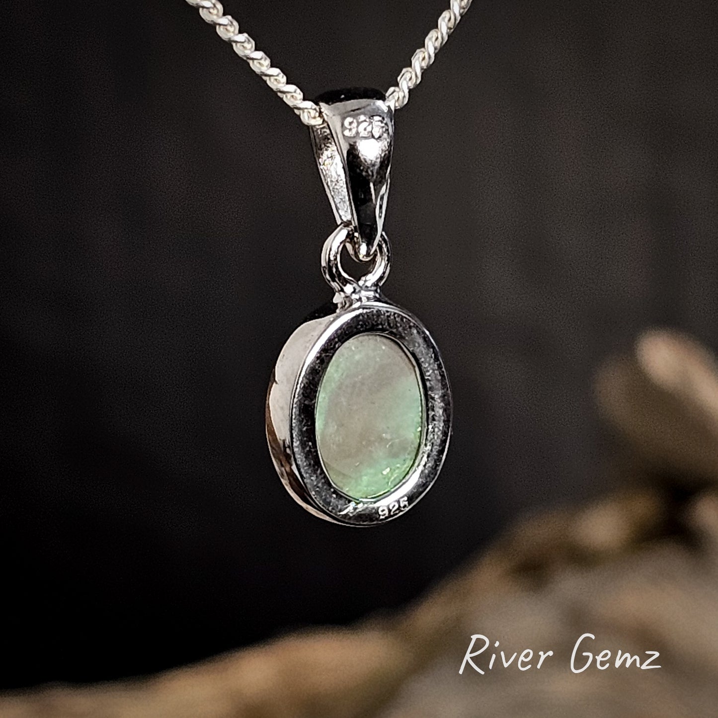 Rear of pendant showing the 925 stamp for sterling silver and the dark tone of the semi-black opal a dark background, featuring 'River Gemz' branding.