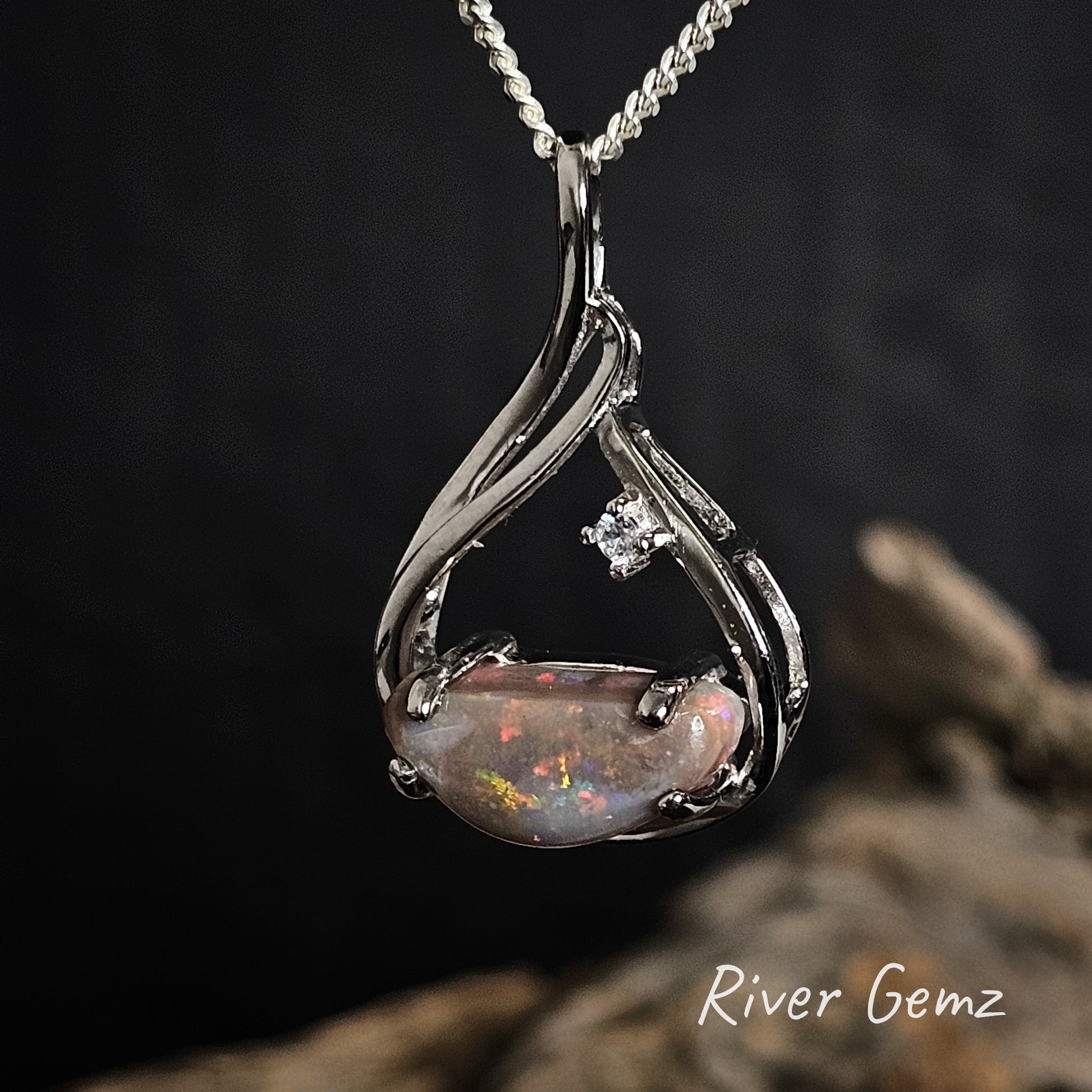 Dark opal and white topaz claw set in sterling silver necklace.