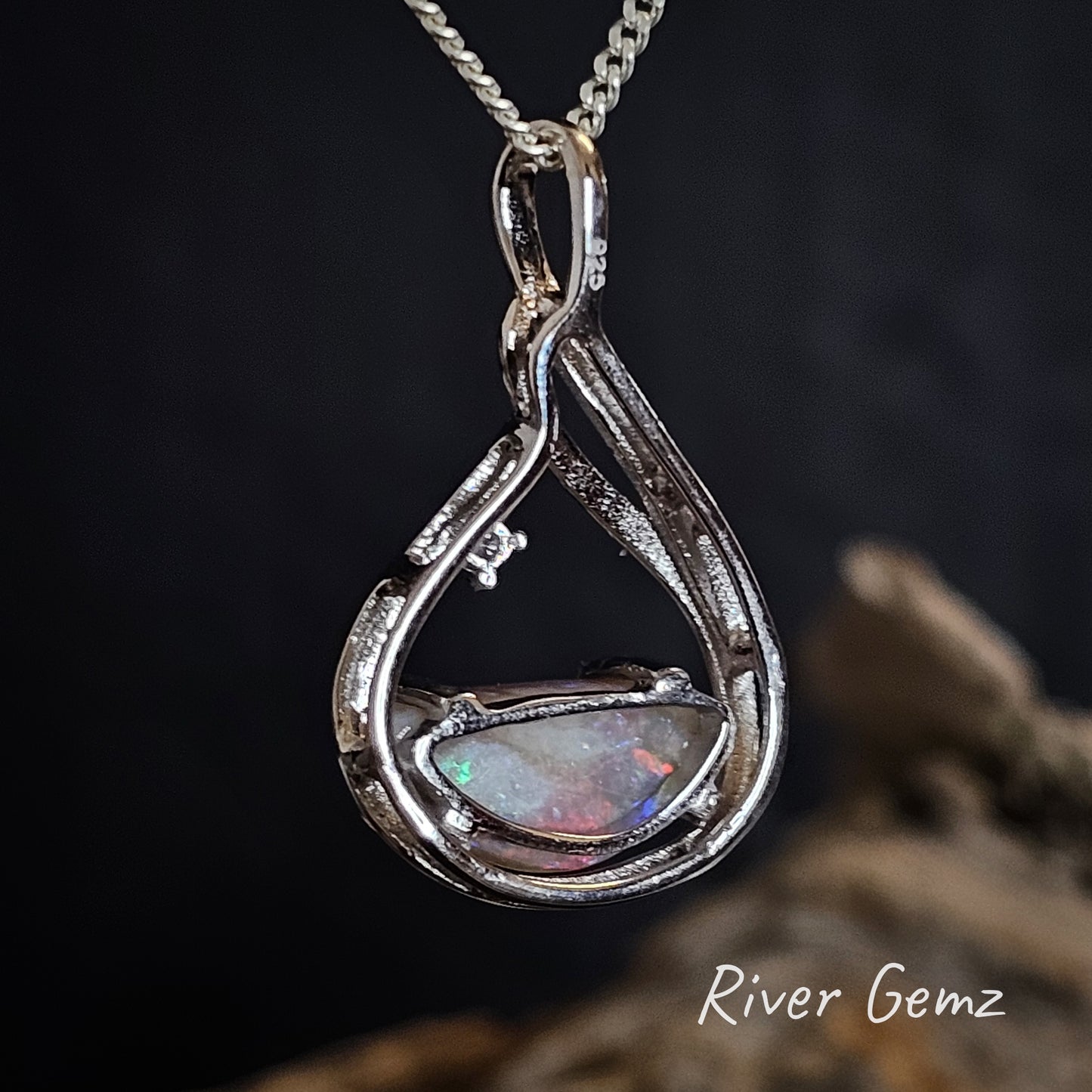 Rear of silver pendant shows the dark grey base of the semi-black opal and the 925 stamp to indicate sterling silver.