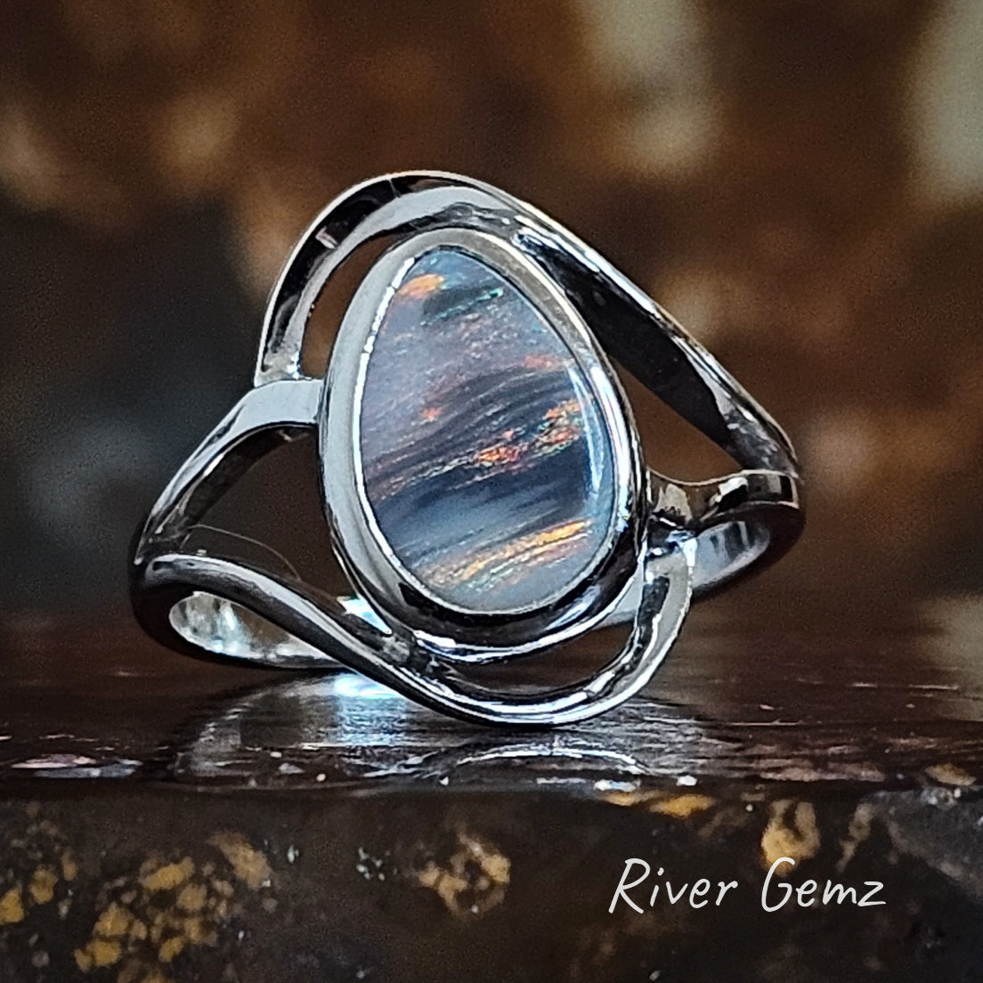 Sunset colours in striped pattern in the semi-black opal sterling silver ring.