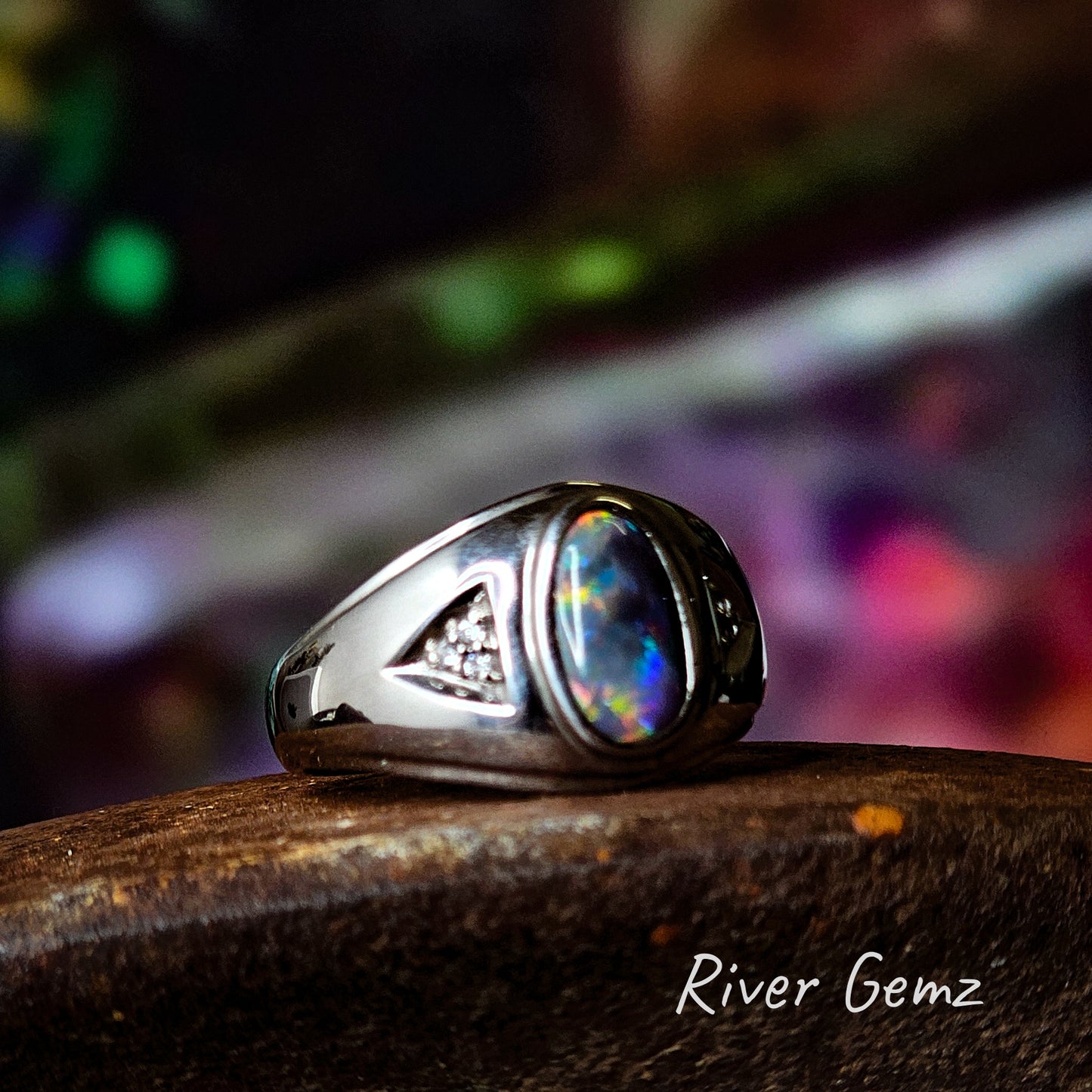 Multi-coloured dark opal set in a modern design men's sterling silver ring.