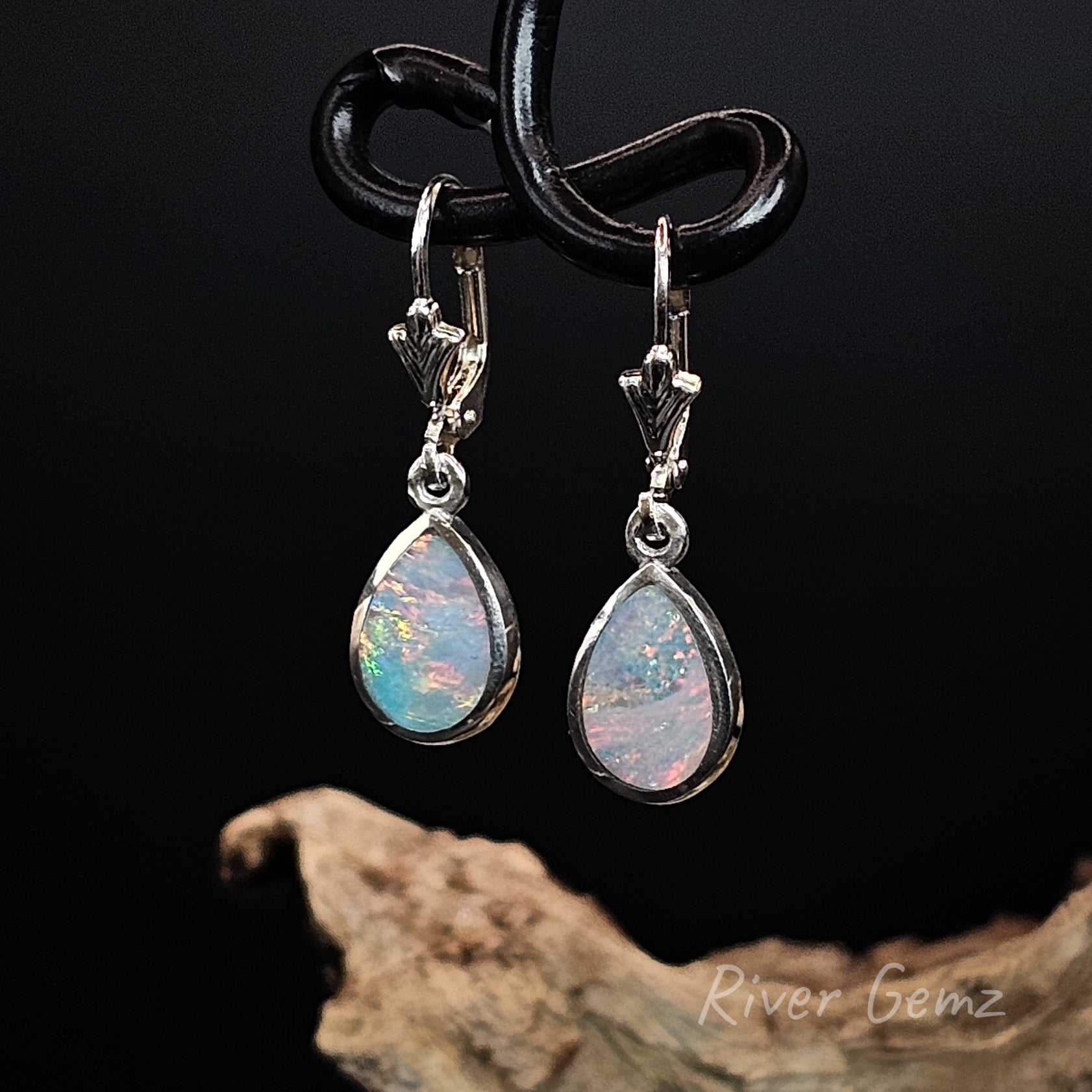 Opal earrings with silver clasps on a dark background, featuring 'River Gemz' branding.