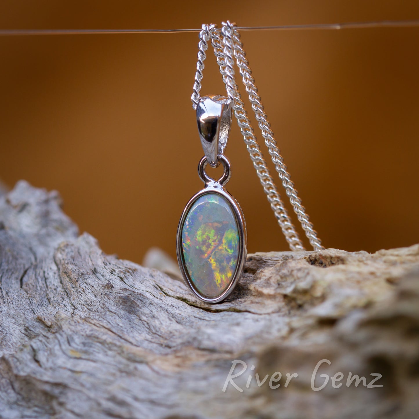 Multi-coloured opal in classic style setting includes large tapered bail.