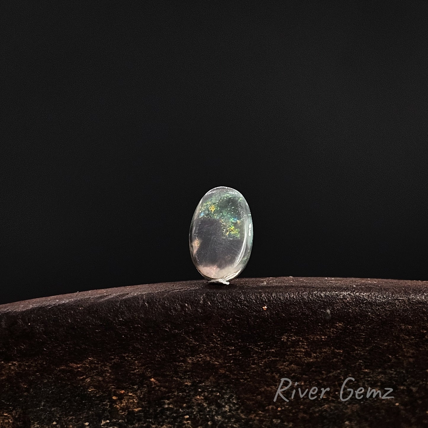 Rear view of the loose stone shows the dark base tone of the black opal.