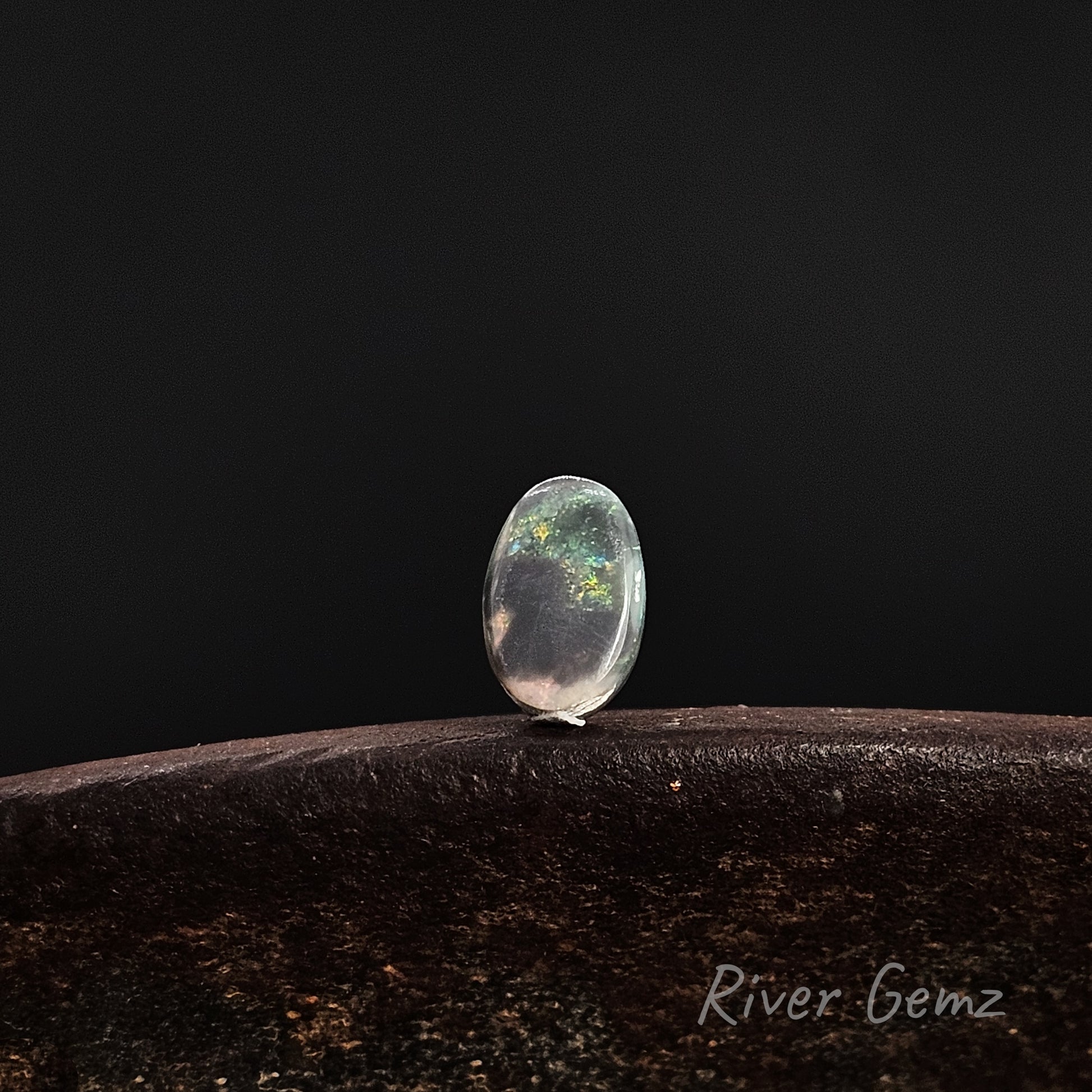 Rear view of the loose stone shows the dark base tone of the black opal.