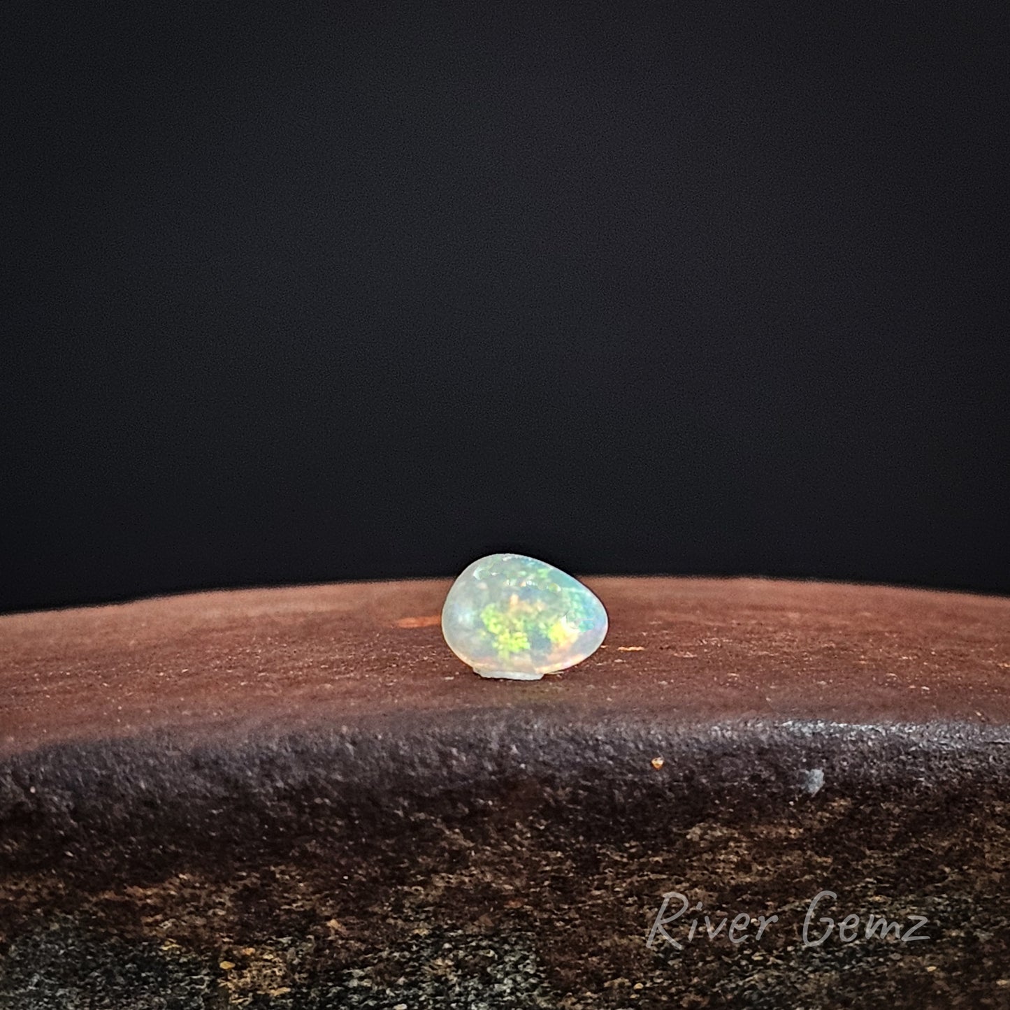 Multi-coloured crystal opal stone on a dark background