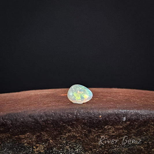 Multi-coloured crystal opal stone on a dark background