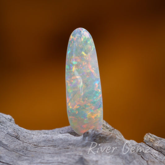 4 photos and 2 videos of the opal are shown. The opal is long and approximately oval shaped.