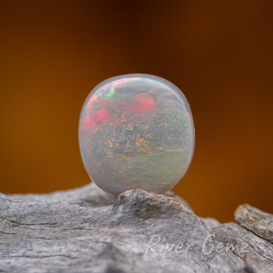 Swirls of colour in the light loose circular-shaped opal.