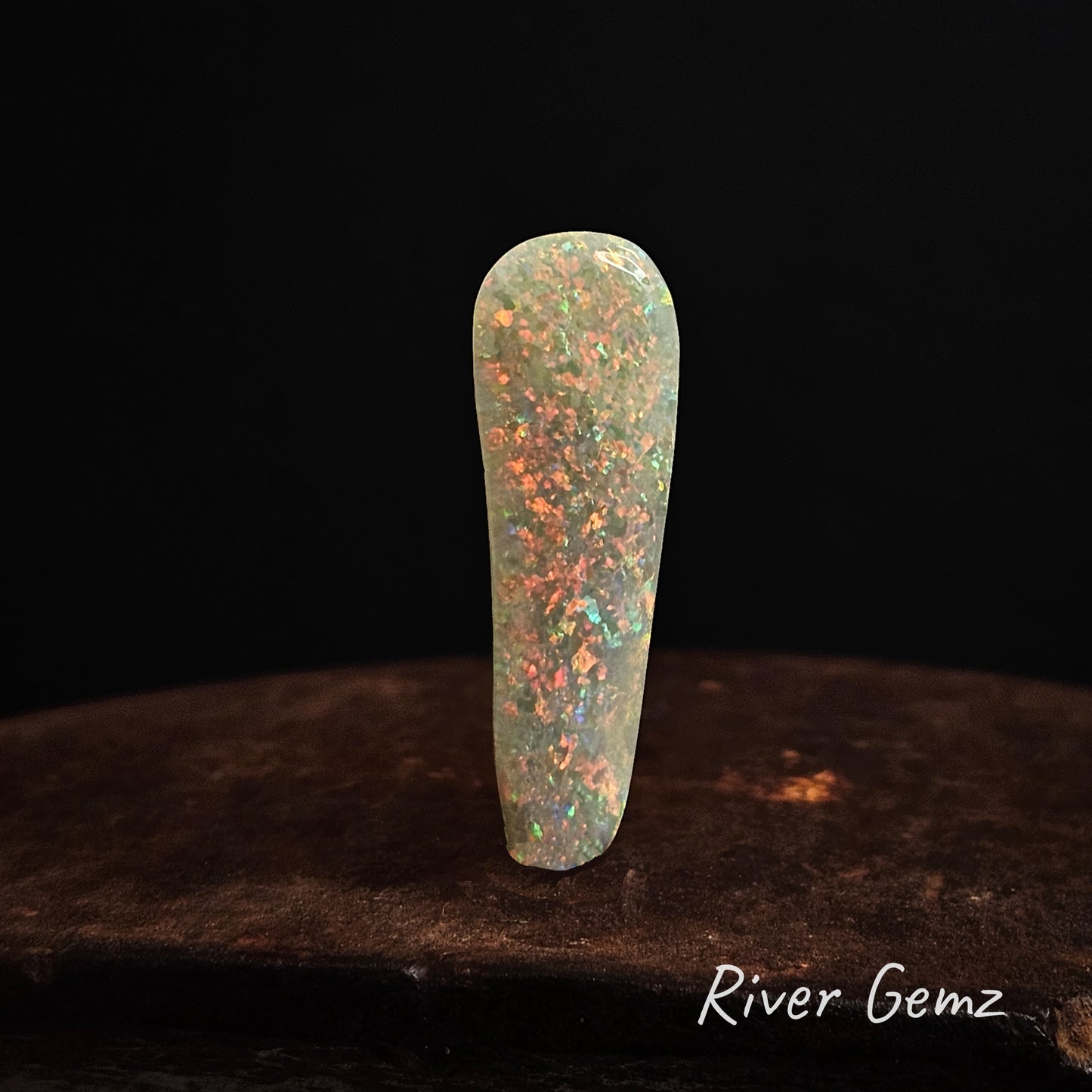 Opal stone on a dark background with 'River Gemz' branding