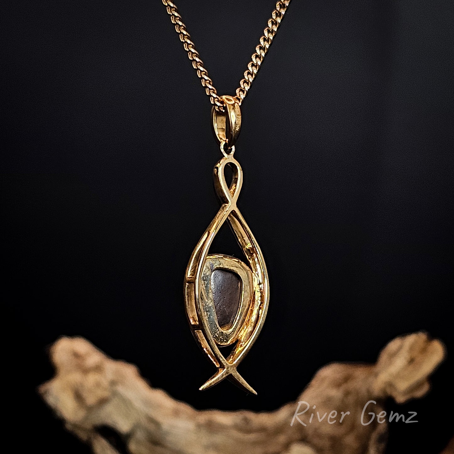 Rear view of gold pendant showing the ironstone matrix of the boulder opal set in it.
