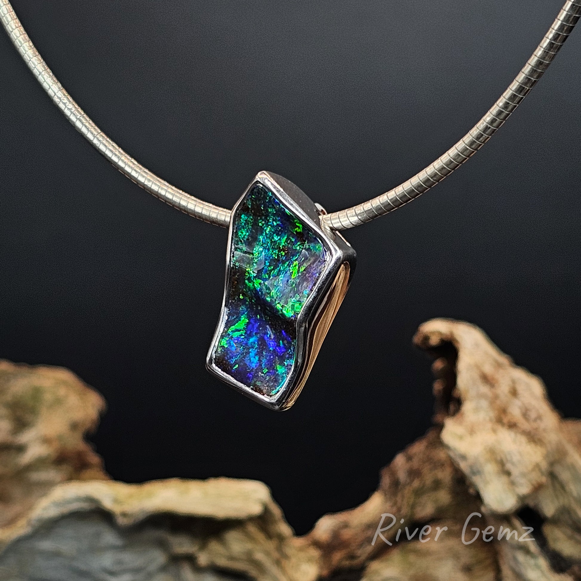 Undulating boulder opal set in sterling silver pendant with an omega chain.