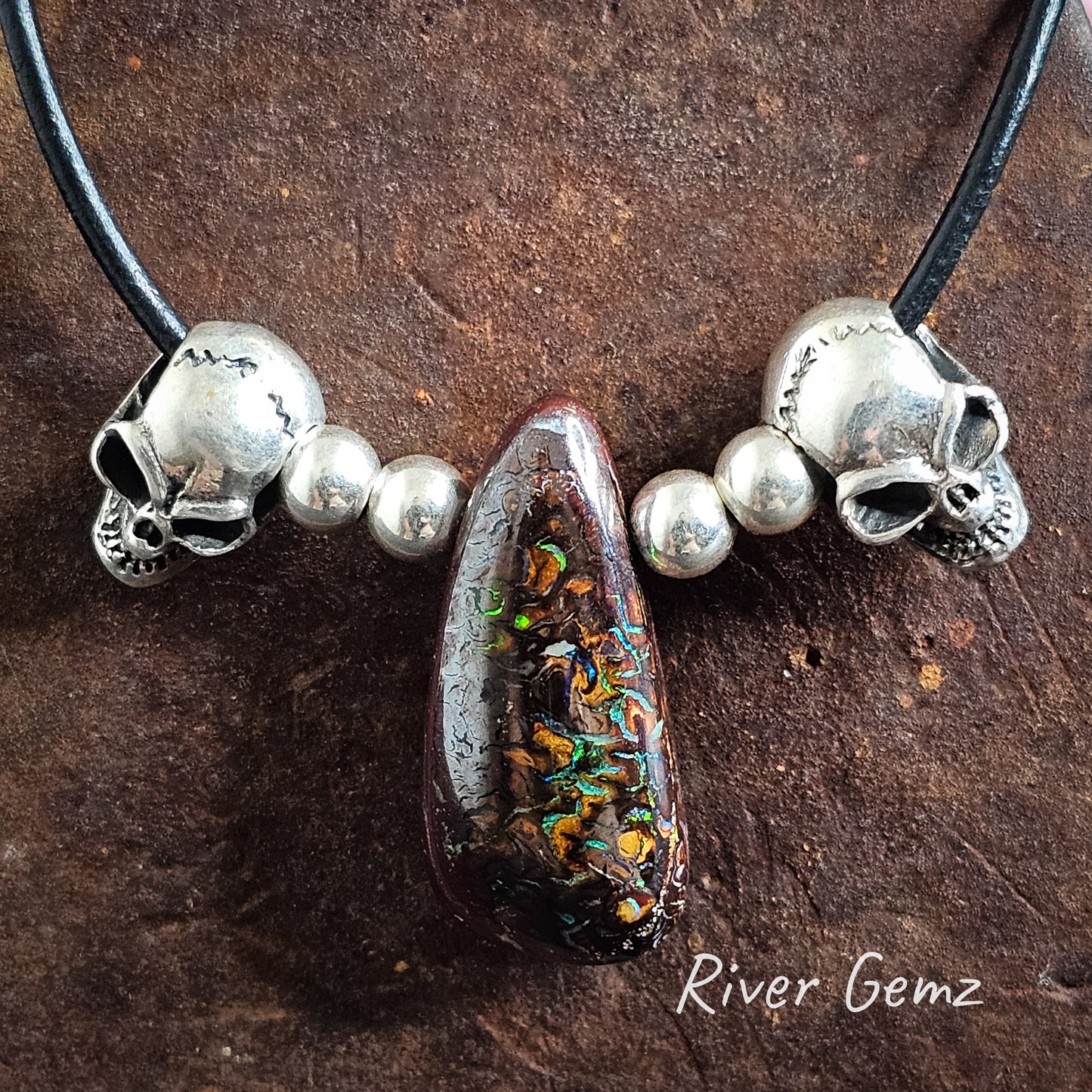 Rounded triangular shaped boulder matrix opal with silver balls and skulls  all on leather cord.